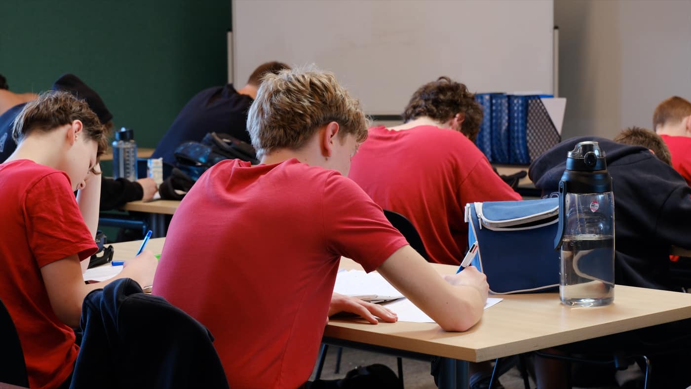 Students writing at their desks in a classroom at FDSA