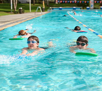 Students swimming laps with kickboards