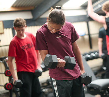 Two students training with dumbbells
